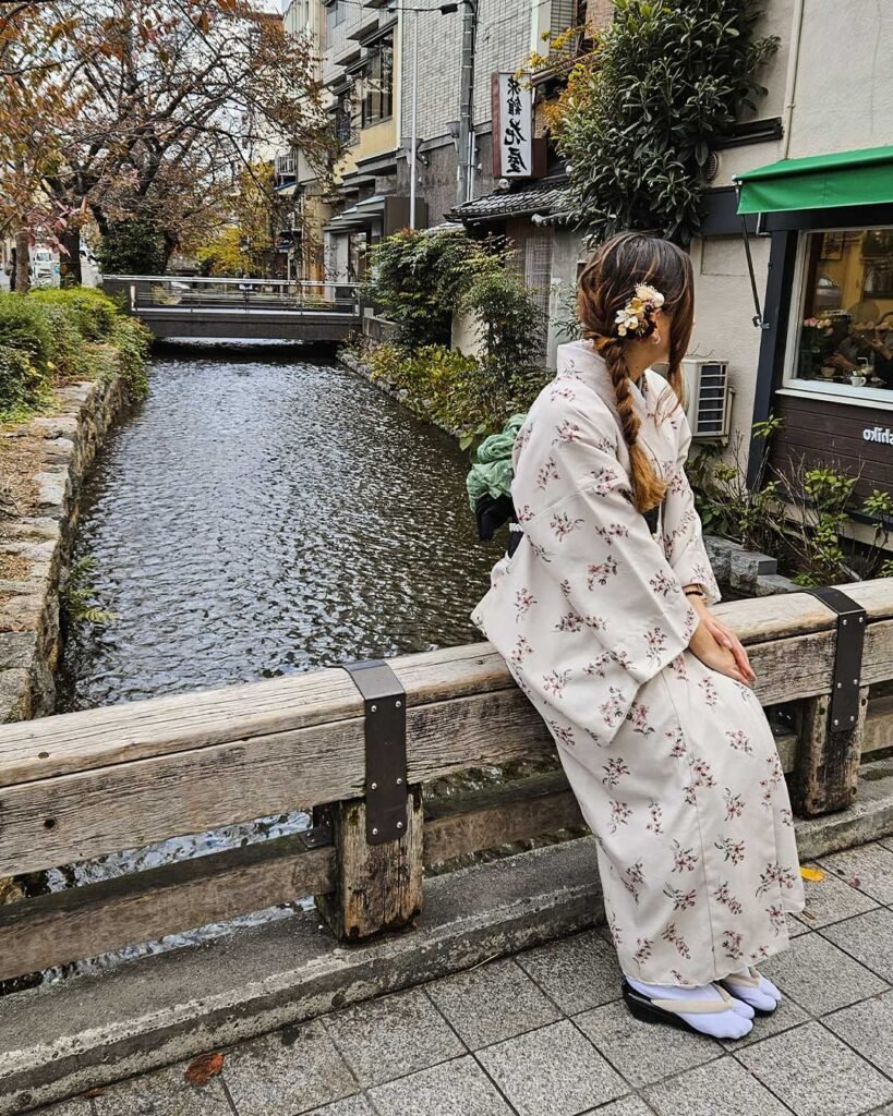 Francesca Barillaro in yukata seduta vicino a un canale in una strada tradizionale giapponese